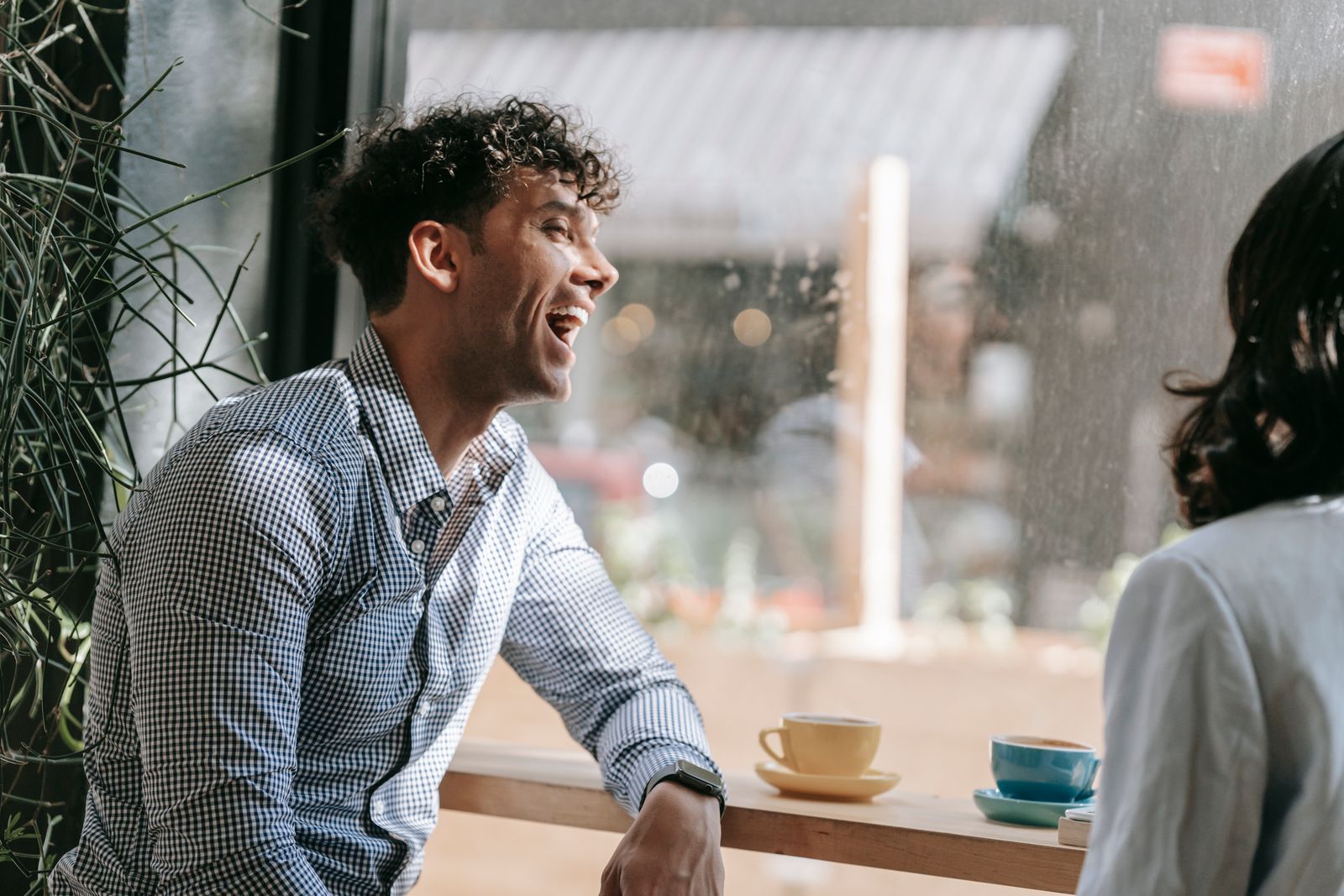 Homme riant assis dans un café